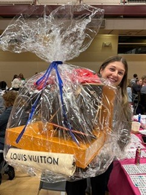 A lucky winner with her designer bag prize
