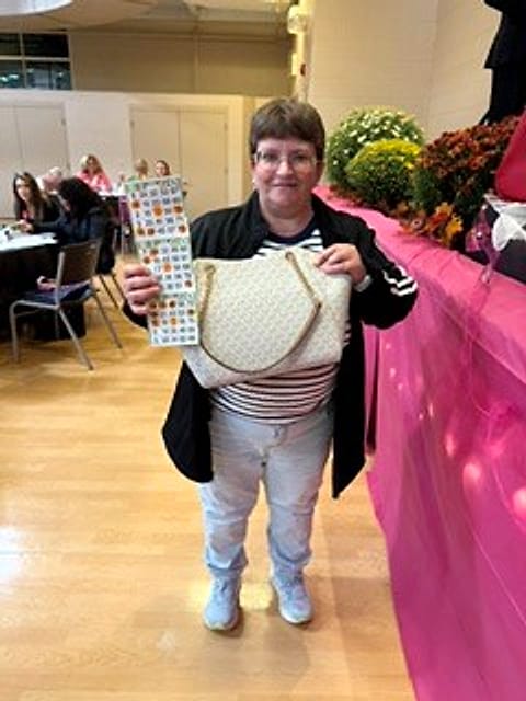 A winner showing off her prize and bingo card