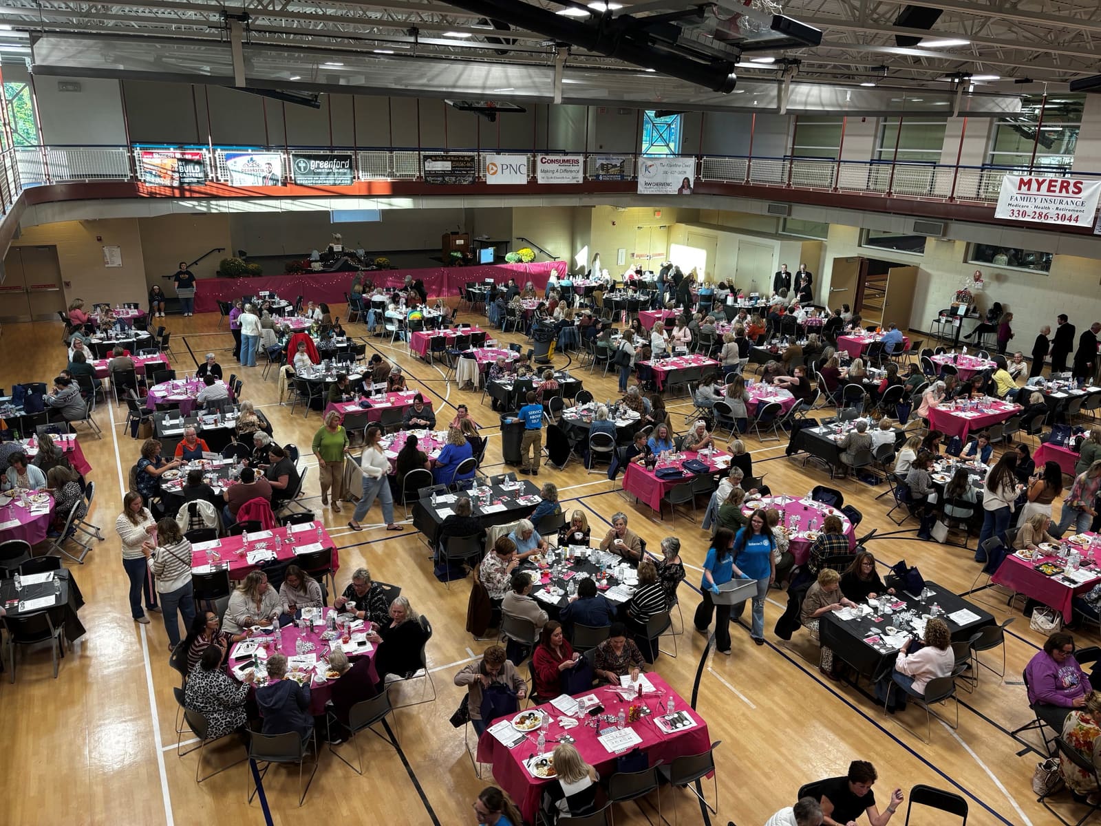 A packed gym of guests at pink-draped tables during Women's Night Out 2026