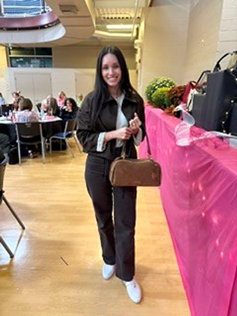 A smiling guest with her new designer handbag